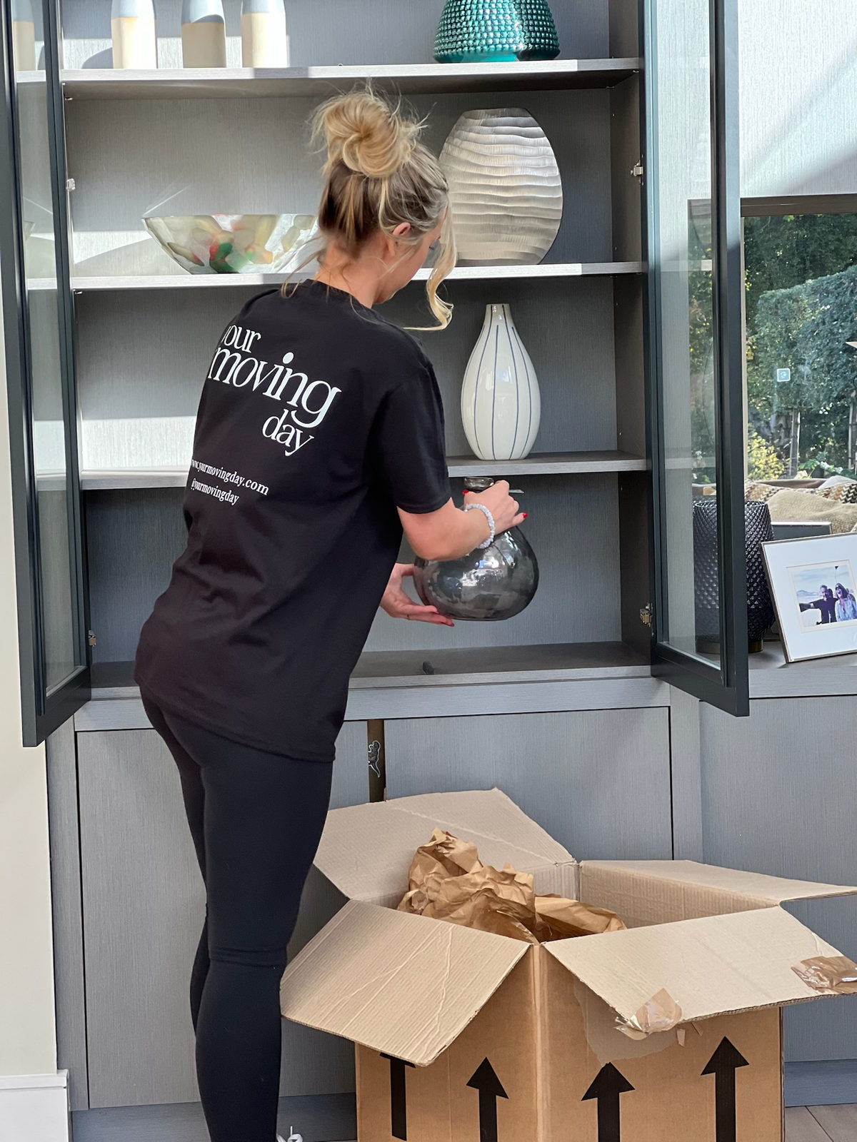Professional organiser helping with moving home, unpacking and setting up practical storage systems